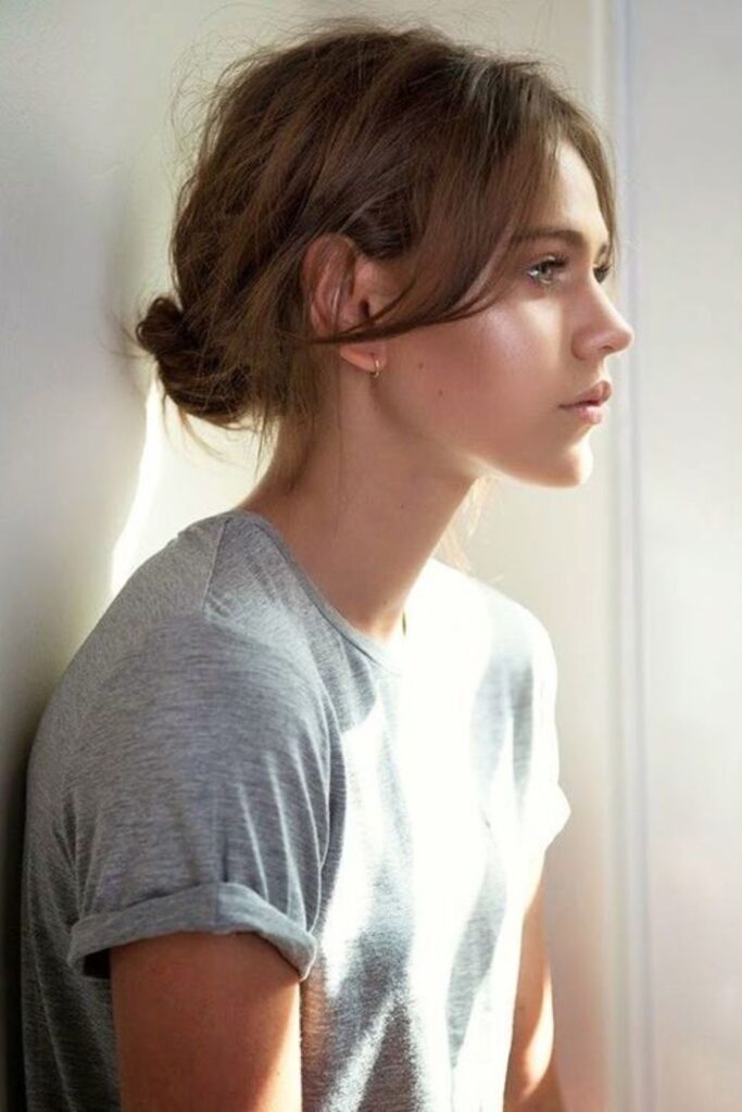 Low Messy Bun with Wispy Bangs Effortlessly Cool